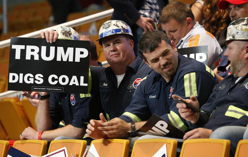 A group of coal miners hold Trump signs as they wait for a rally with Republican presidential candidate Donald Trump, Thursday, May 5, 2016, in Charleston, W.Va. (AP Photo/Steve Helber)