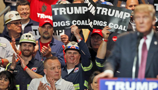 FILE- In this May 5, 2016 photo, Coal miners wave signs as Republican presidential candidate Donald Trump speaks during a rally in Charleston, W.Va. Trump's election could signal the end of many of President Barack Obama's signature environmental initiatives. Trump has said he loathes regulation and wants to use more coal and expand offshore drilling and hydraulic fracturing. (AP Photo/Steve Helber, File)