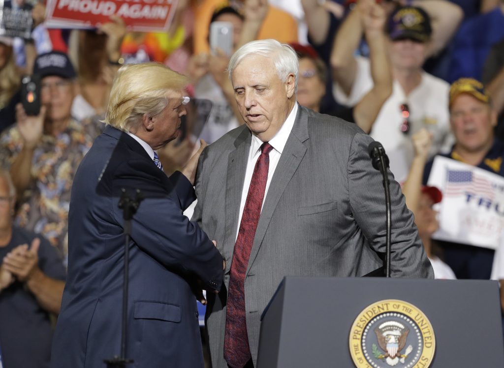 President Donald Trump talks with West Virginia Gov. Jim Justice during a rally Thursday, Aug. 3, 2017, in Huntington, W.Va. Justice, a Democrat, announced that he is switching parties to join the Republicans. (AP Photo/Darron Cummings)
